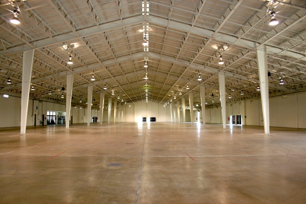 A large empty warehouse with lights on the ceiling.